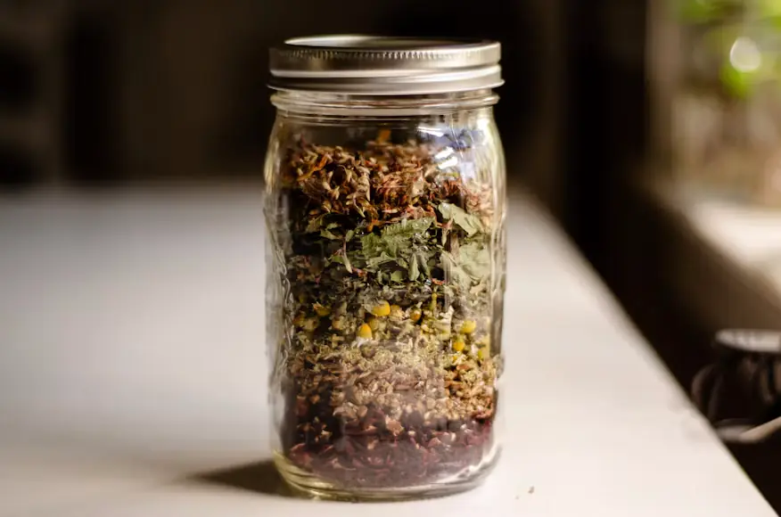 Tarro de cristal con una mezcla de hierbas secas para infusión